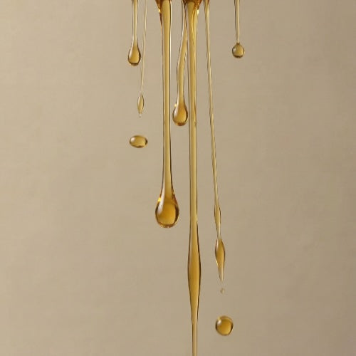 Gold liquid droplets on a beige background