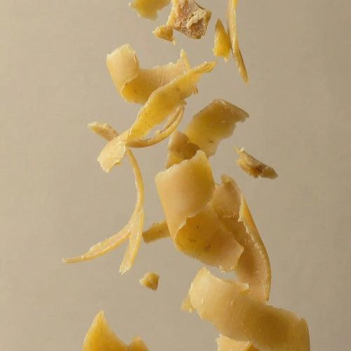 Beeswax falling against a beige background