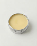 Silver tin with beige cream on a white background