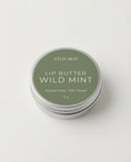Lip butter container labeled 'Wild Mint' by Veld Skin on a light gray background