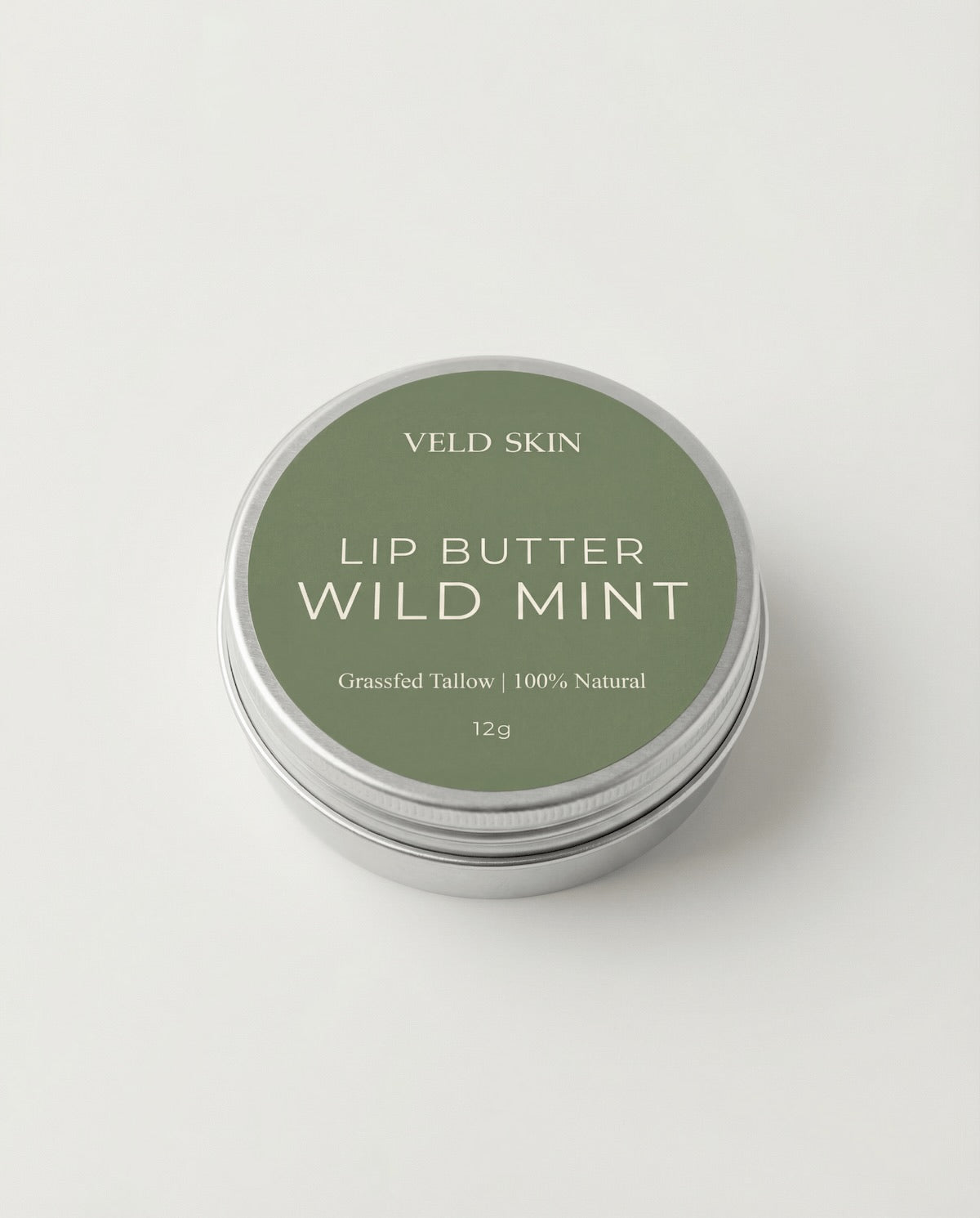Lip butter container labeled 'Wild Mint' by Veld Skin on a light gray background