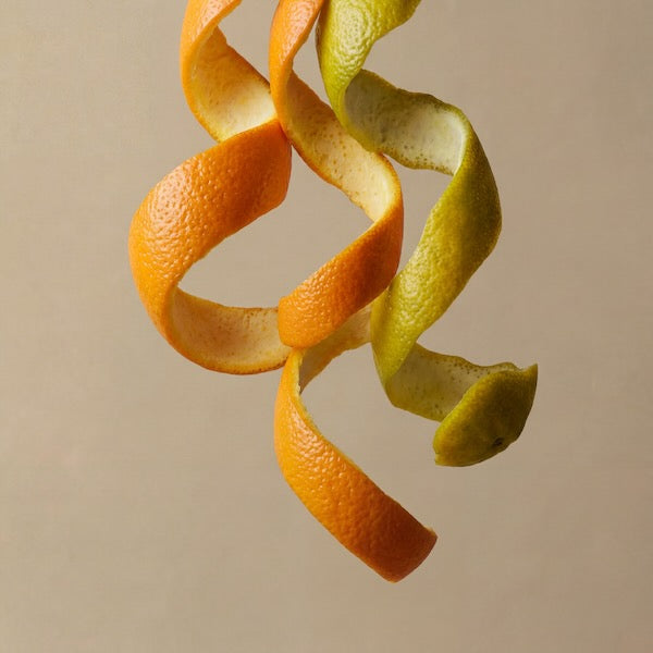 Twisted orange and lemon peels on a beige background