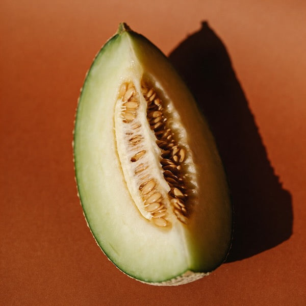 Halved melon on a brown background