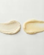Two smears of cream on a light gray background
